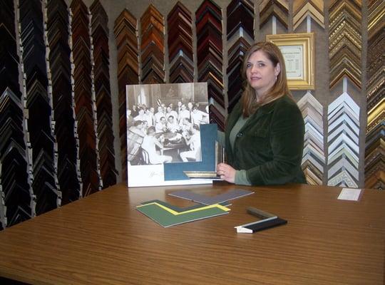 Tanya Gemmer displays samples of moulding and mat next to a photo to be framed.