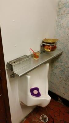 Best urinal ever. Ash tray welded to the shelf? Check. Brass spitoon padlocked to the shelf? Check. Classic.