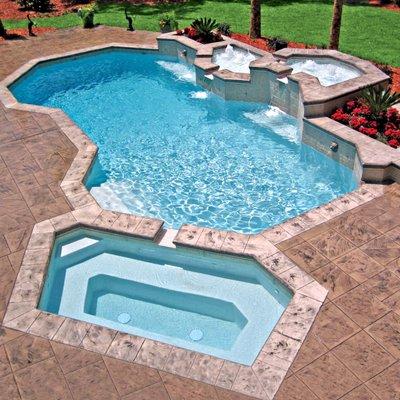 Geometric-shaped concrete pool with elevated enclosures of bubbler fountains, custom geometric spa, and lion-head water sconces