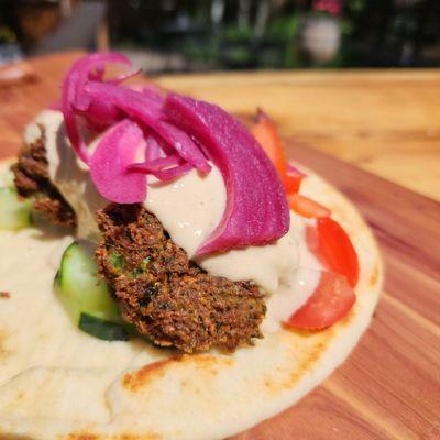 Homemade Falafel with lemon tahini, pickled red onion, tomato, cucumber. (Vegan)