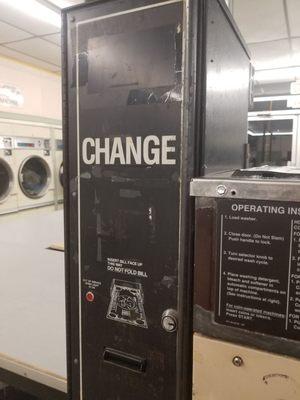 Dirty broken change machine and rusty washer.