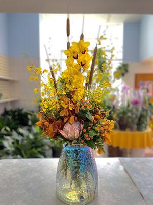 Fall colored orchids centered with King Protea