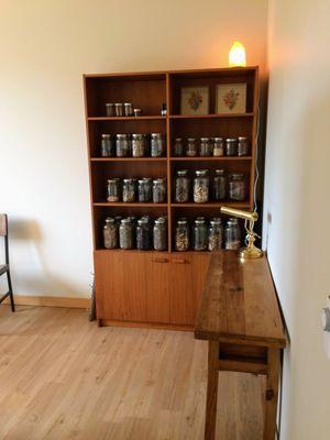 Large shelf with jars of raw herbs