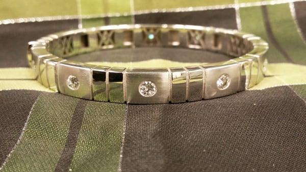 Custom remake of a plastic bracelet into a 14k white gold and diamond bangle.