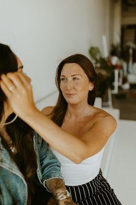 Libby styling model for photoshoot, highlighting her lashes..