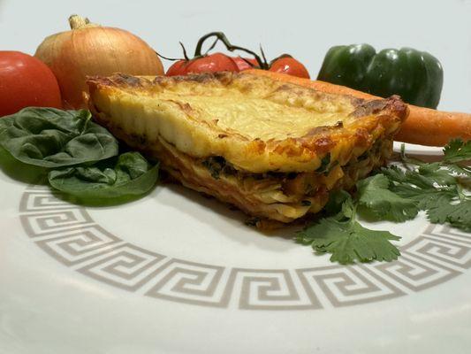 Our vegetarian lasagna, made with layers of noodles, onions, carrots, spinach, spices, creamy ricotta, and mozzarella, topped with béchamel.