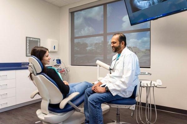 Dr. Varkey speaking with a patient during their visit at Advanced Family Dental of Midlothian