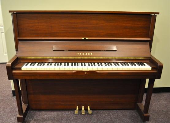 Yamaha upright piano in walnut satin.