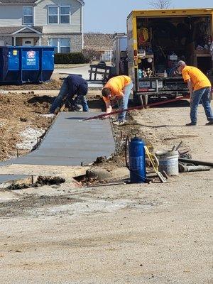 The guys working on some city sidewalk.