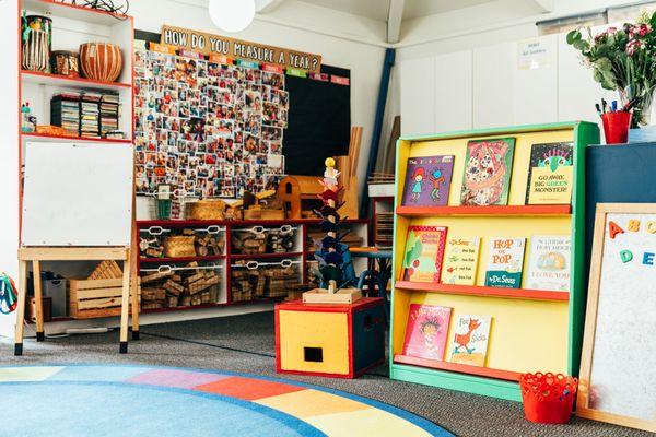 During story time, groups of 5-6 children gather with a working parent who reads stories from the school's vast children's library.