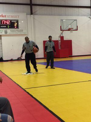 Ref cleaning up water during the games that was dripping from the roof!